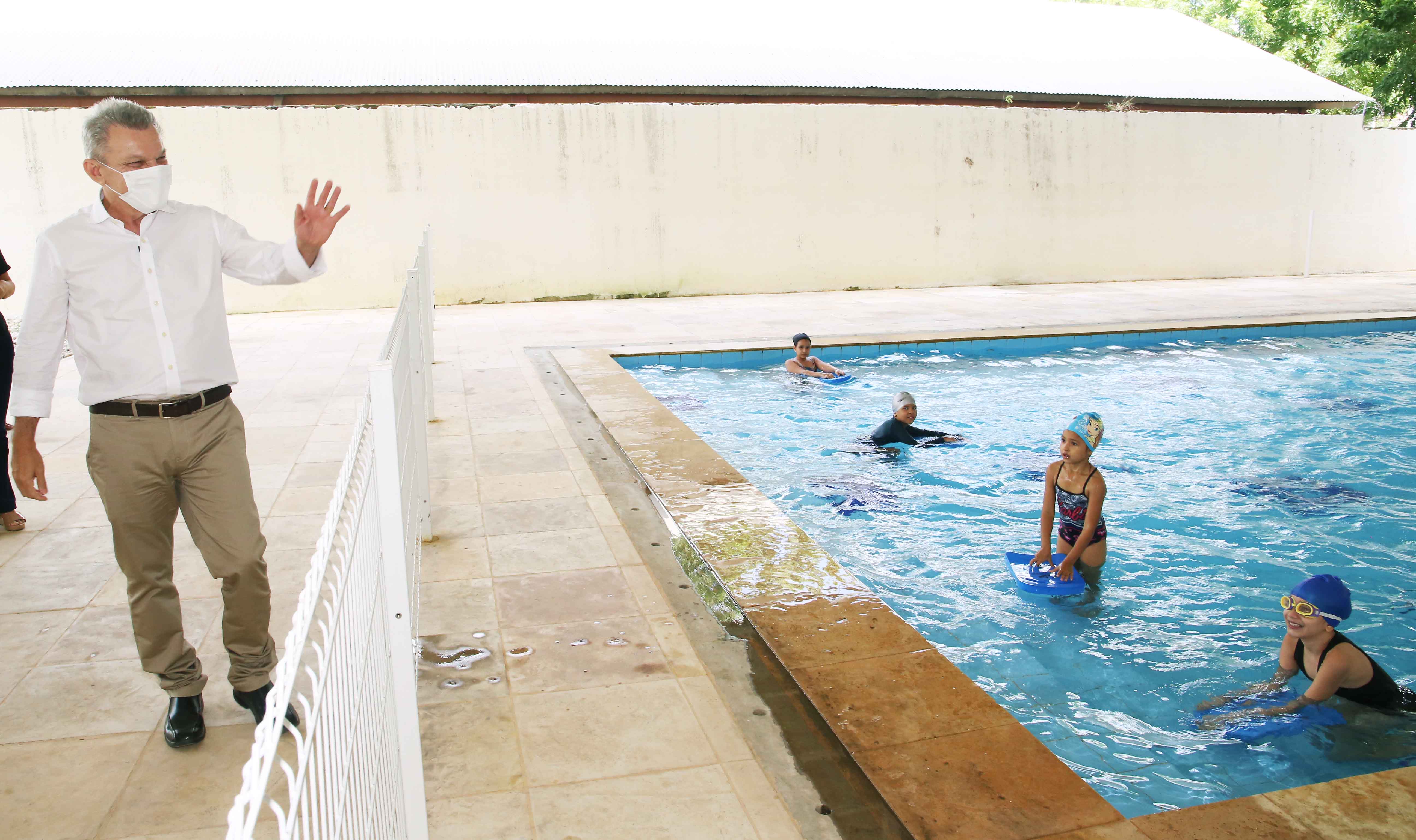 Sarto acena para um grupo de crianças que está dentro de uma piscina